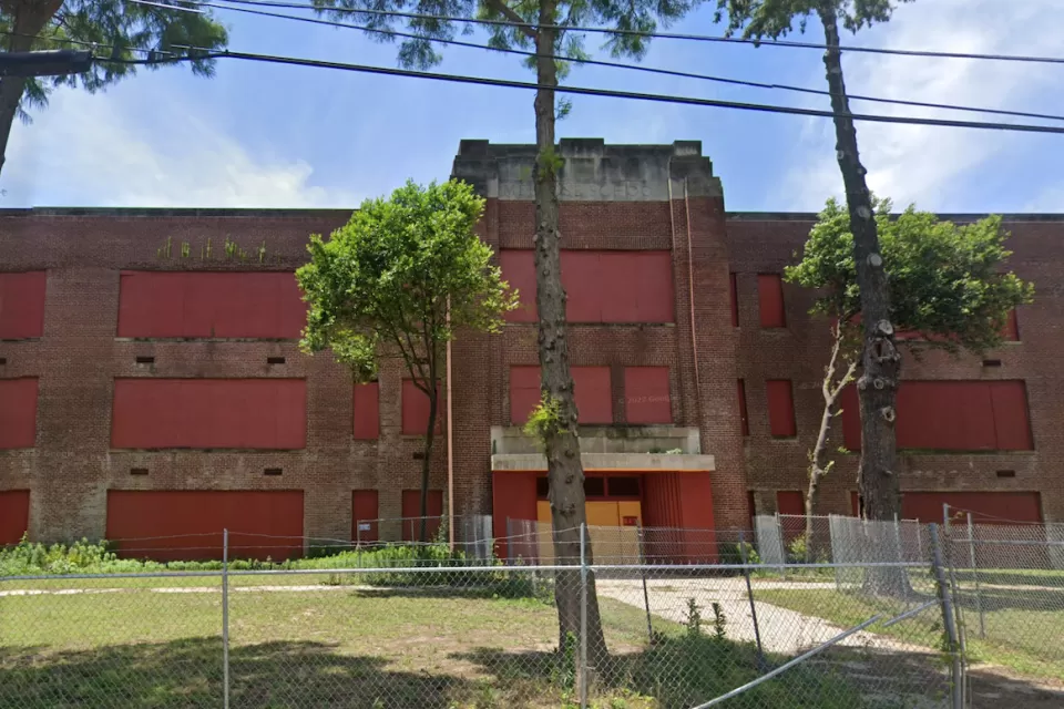 Google street view of vacant, boarded-up brick high school building in Memphis, Tennessee.